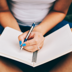 Image of someone with journal and a pen